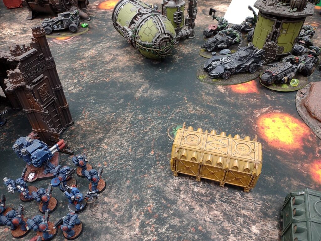 An army of mecha approaches an army of vehicles at a scarred outpost